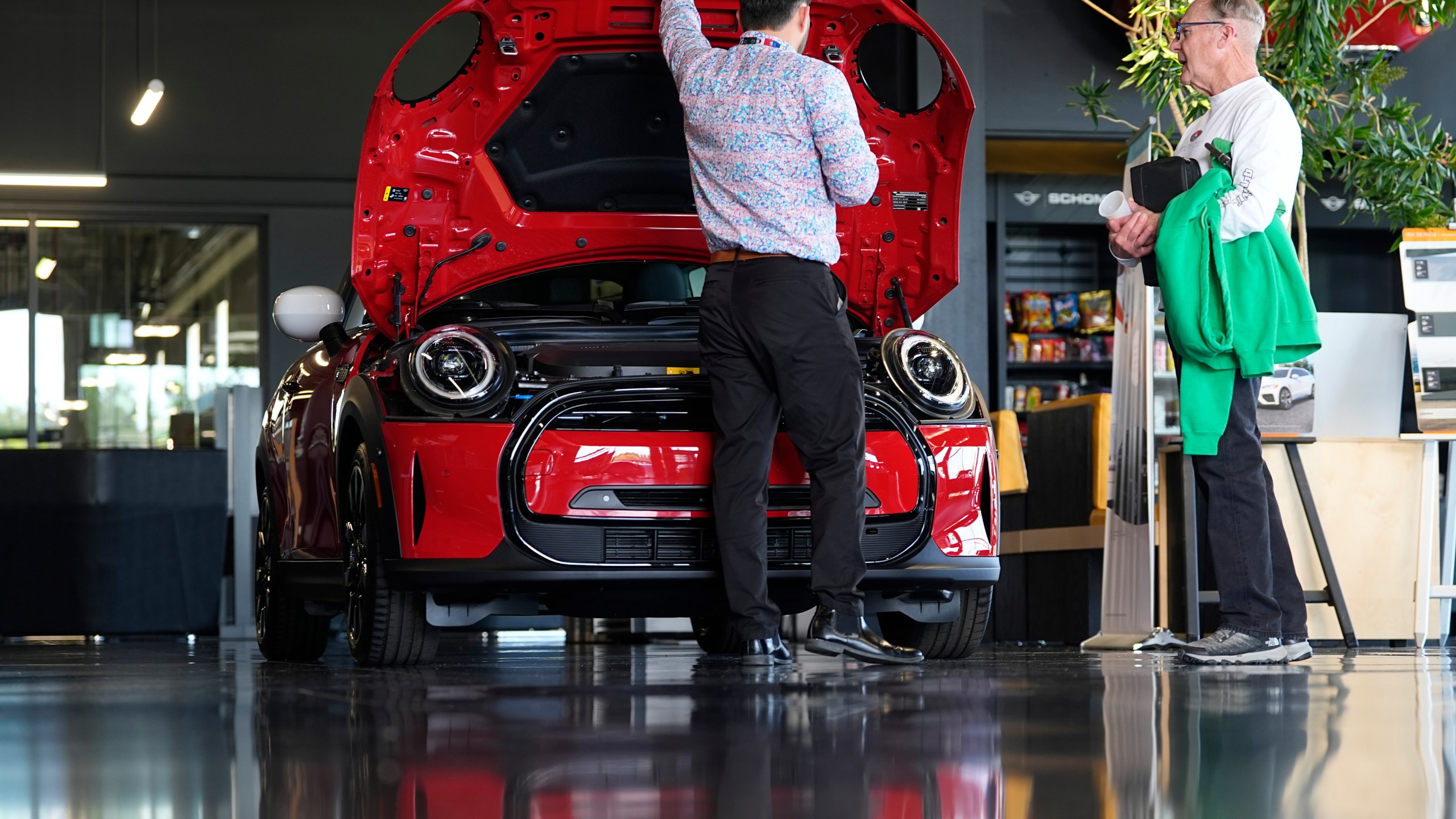 A salesperson shows an unsold 2024 Cooper SE electric hardtop to a prospective buyer at a Mini dealership Wednesday, May 1, 2024, in Highlands Ranch, Colo. On Friday, May 3, 2024, the U.S. government issues its April jobs report. (AP Photo/David Zalubowski)