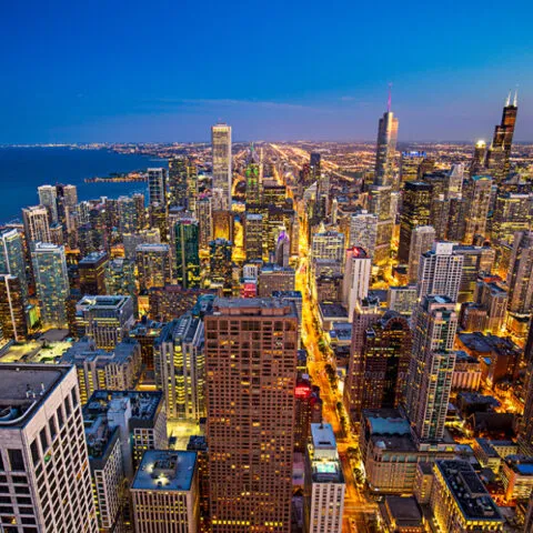 a view of a city at night from the top of a skyscraper