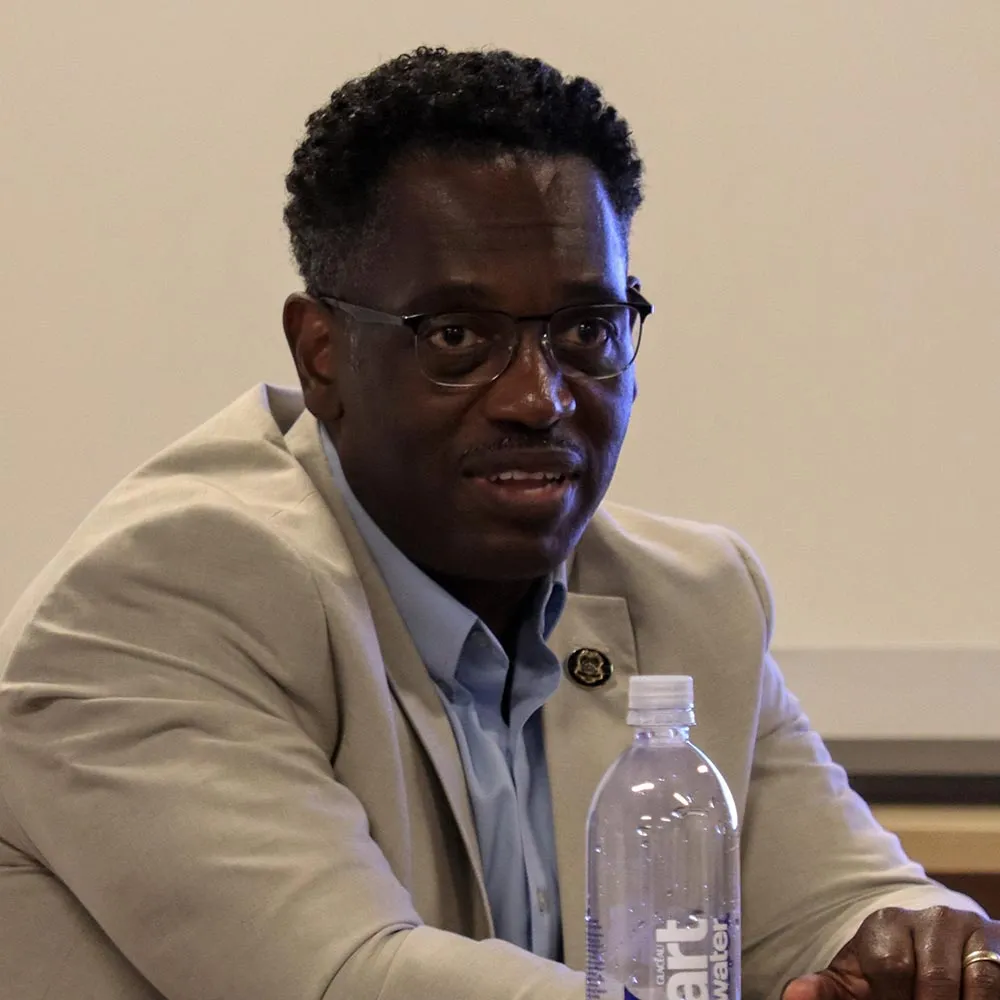 a man sitting at a table with a bottle of water