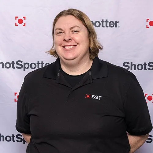 a woman standing in front of a white backdrop