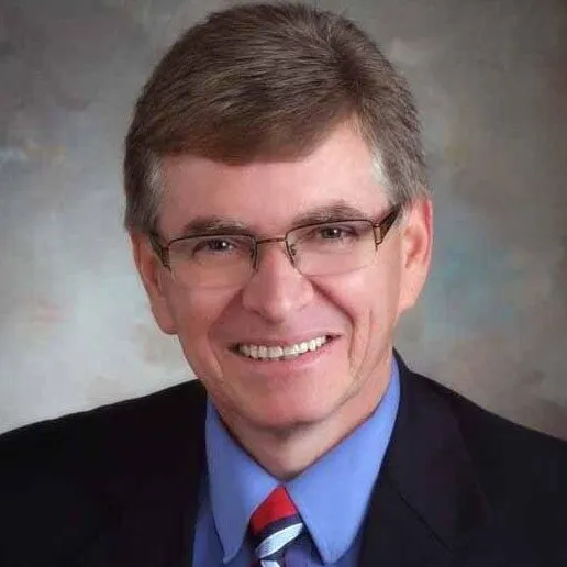 a man in a suit and tie smiling for a picture