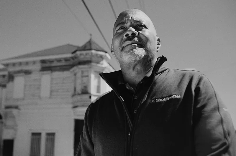 a black and white photo of a man in front of a building