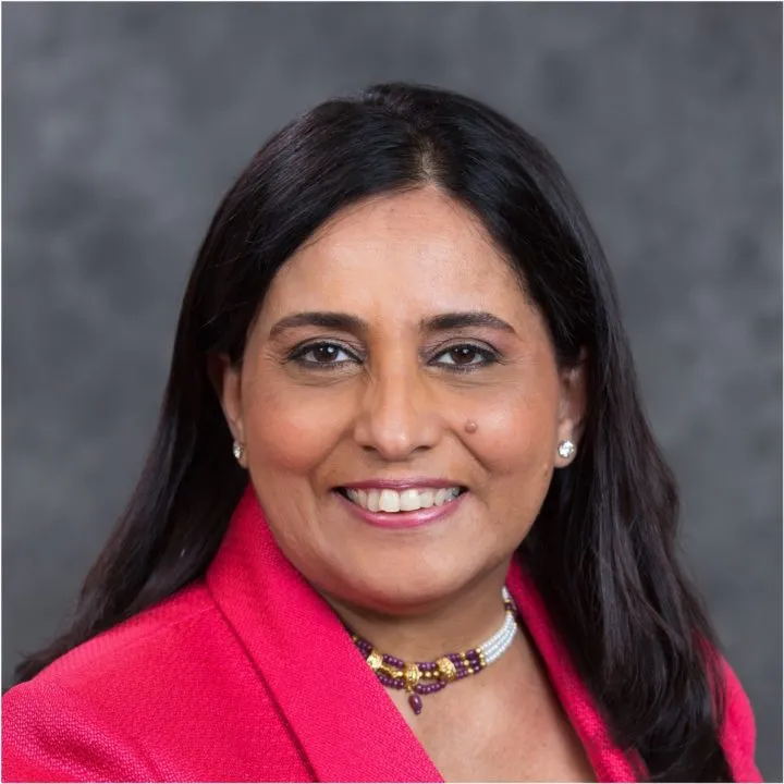 a woman in a pink jacket smiling for the camera