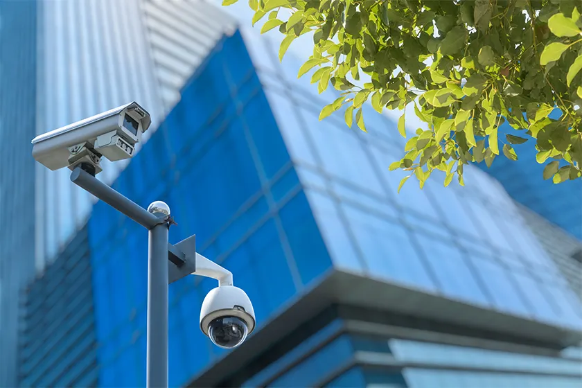 two cameras on a pole in front of a building