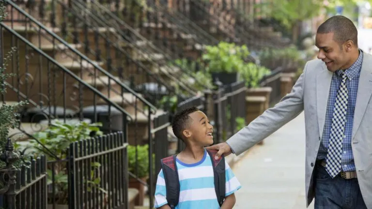 a man holding the hand of a young boy