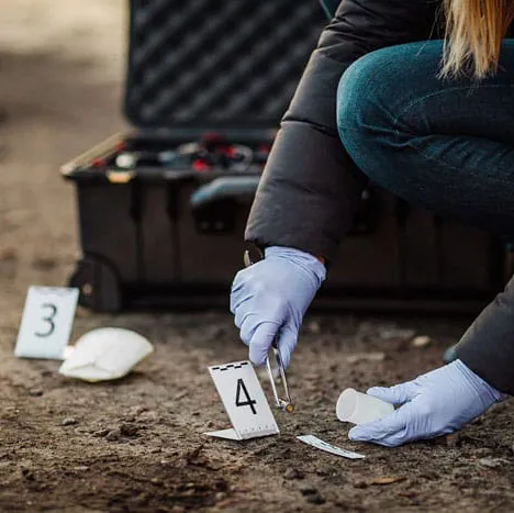 a woman kneeling down next to a piece of luggage