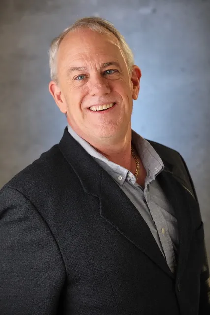 a man in a suit smiling at the camera