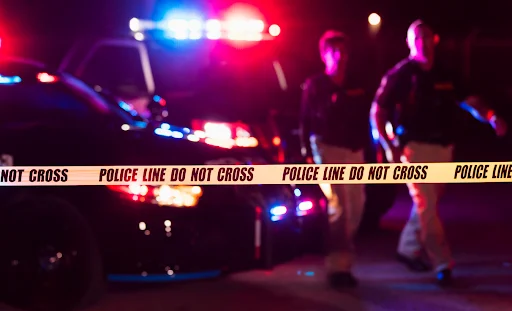 two police officers standing next to a police car