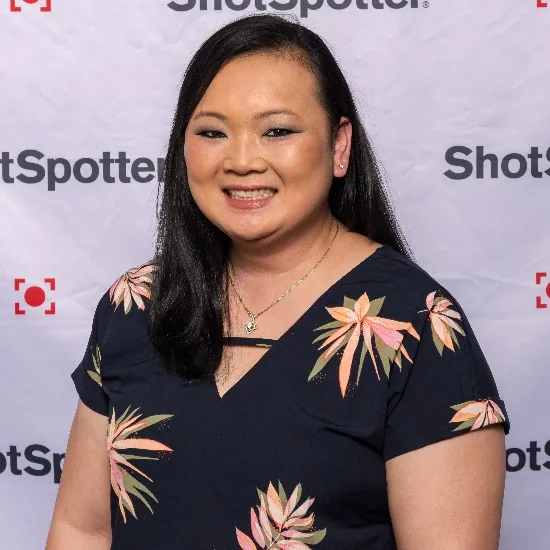 a woman standing in front of a white backdrop