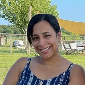 a woman in a blue dress smiling at the camera