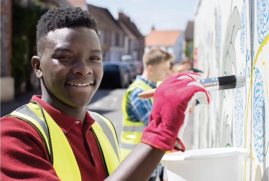 a man in a red shirt is painting a wall